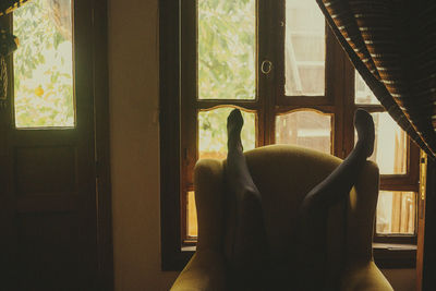 Woman sitting on window at home