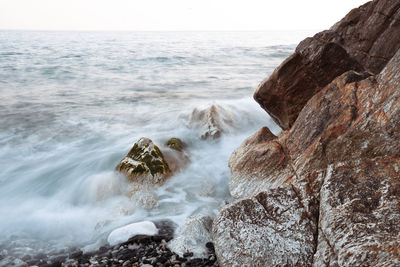 Scenic view of rocks in sea against sky