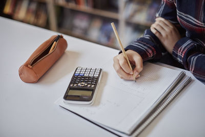 Student using calculator and taking notes