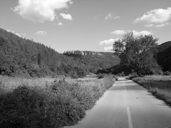 Empty road along countryside landscape