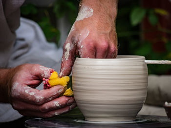 Cropped hands making pot