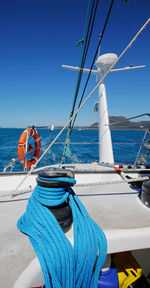 Sailboat sailing in sea against clear blue sky