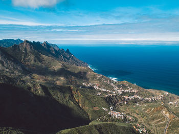 Scenic view of sea and mountains against sky