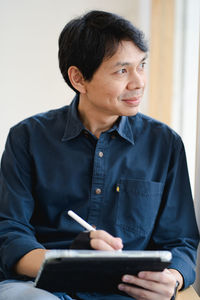 Portrait of young woman using laptop at home