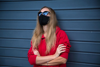 Portrait of woman wearing sunglasses against wall