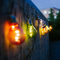 Close-up of illuminated lights against wall at night