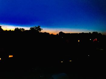 Silhouette trees against sky at night