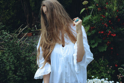 Portrait of woman standing by trees