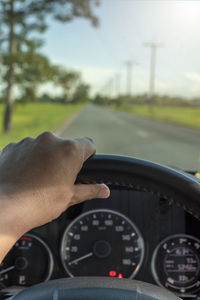 Cropped hand of man driving car