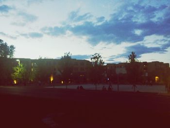 Buildings in city against cloudy sky