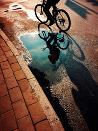 Reflection of man riding bicycle in swimming pool