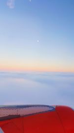 Airplane flying over sea against sky during sunset