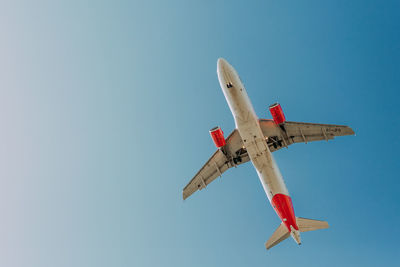 Low angle view of airplane flying against clear sky