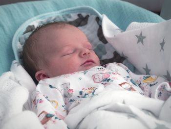 High angle view of cute baby girl sleeping on bed