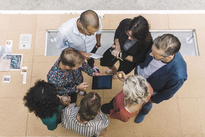 High angle view of businessman discussing over digital tablet with colleagues in portable office truck