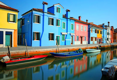 Burano isalnd near venice in italy and reflection over the navigable waterway of the colorful houses