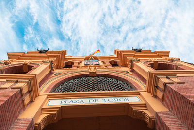 Low angle view of building against cloudy sky