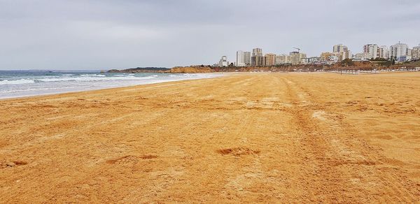 Scenic view of beach against sky in city