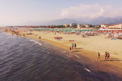 People at beach against sky