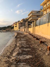 Scenic view of beach by buildings against sky