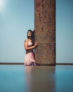 Portrait of woman sitting against clear sky