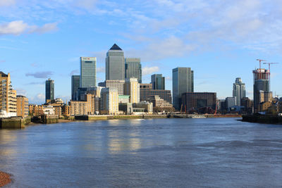 Skyscrapers in city against cloudy sky