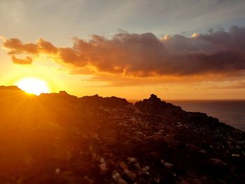 Scenic view of silhouette mountains against sky during sunset