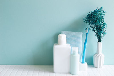 White bottles on table against wall