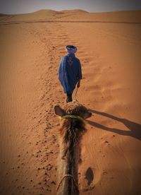 Man with umbrella on sand in desert