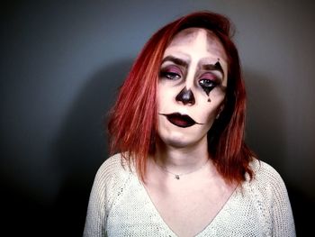 Portrait of young woman against black background