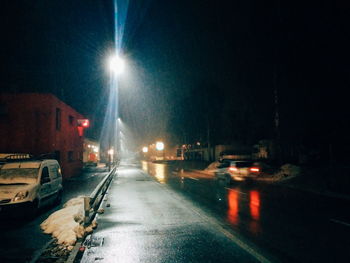 Road passing through illuminated city at night