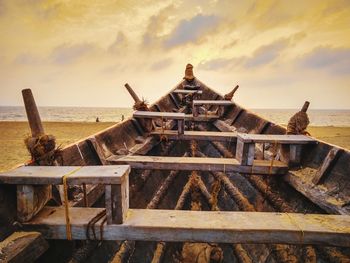 Built structure on beach against sky during sunset