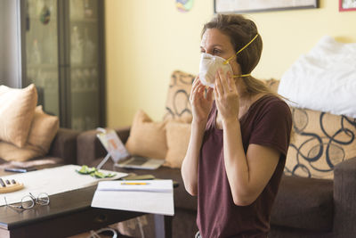 Side view of woman using mobile phone at home