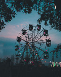 Low angle view of ferris wheel against sky at sunset