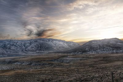 Scenic view of snowcapped mountains against sky during sunset