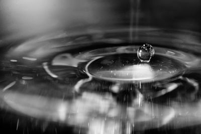 Close-up of water drop falling on metal
