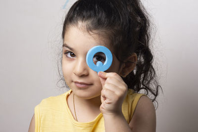 Close-up of young woman with eyes closed against wall