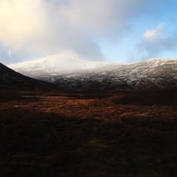 Scenic view of mountains against cloudy sky