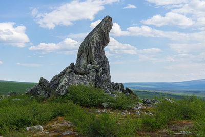 Castle on rock by sea against sky