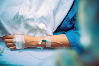 Close-up of woman hand with medical equipment on bed