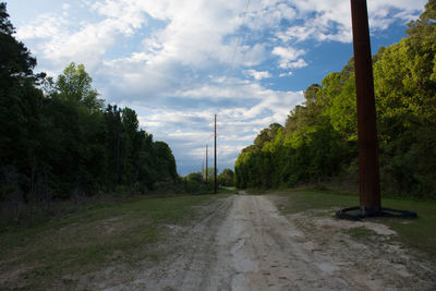 Road amidst trees against sky