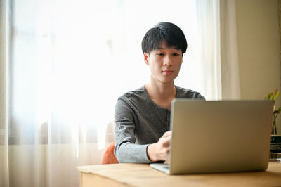 Businesswoman using laptop at home