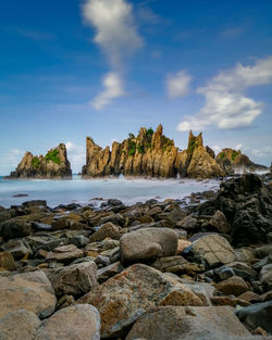 Rocks on beach against sky