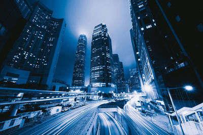 Aerial view of illuminated street amidst buildings at night