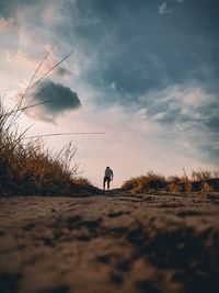 Man standing on mountain against sky during sunset