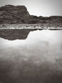 Surface level of rocks by sea against sky