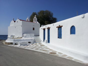 Whitewashed building against sky during sunny day