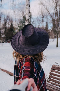 Portrait of woman wearing hat against trees during winter