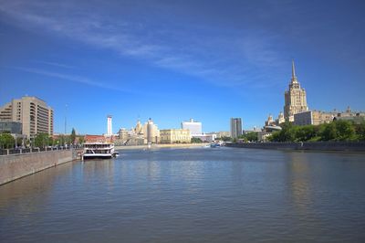 River by buildings against sky in city