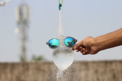 Midsection of man with bubbles in swimming pool against sea